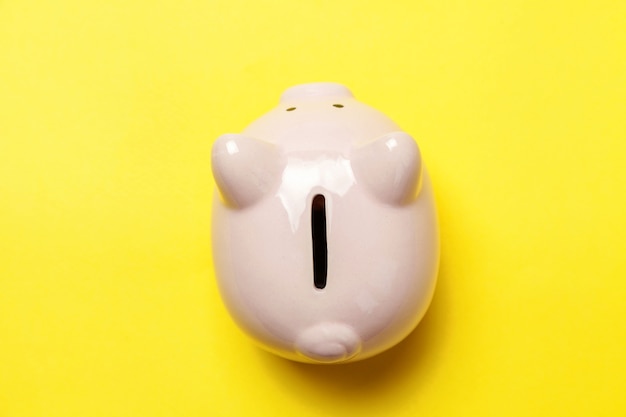 Saving investment budget wealth retirement financial money banking concept. Pink piggy bank isolated on yellow colourful trendy modern fashion background. Flat lay top view copy space