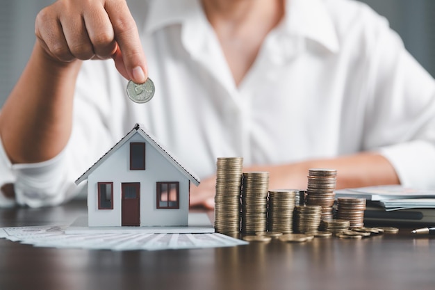 Saving investment home with loan finance money business concept\
investment banking finance for residential real estate business\
stack coins with model house for investment loanscash for\
taxes