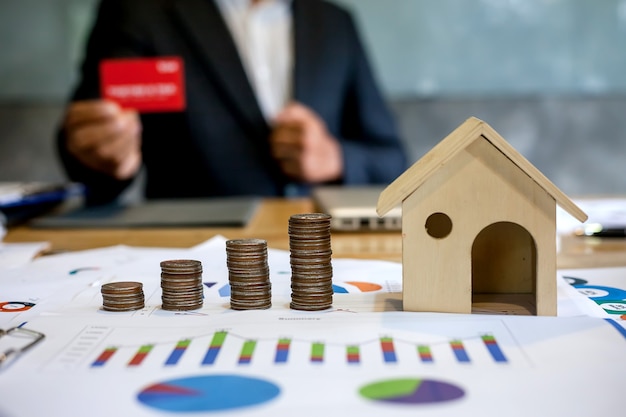 Saving money to buy a house. businessman holding a red credit card