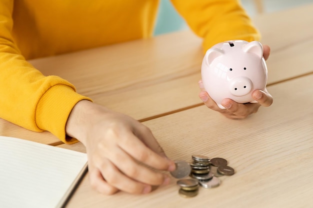 Saving money investment for future Female woman hands holding pink piggy bank and putting money coin Saving investment budget business wealth retirement financial money banking concept