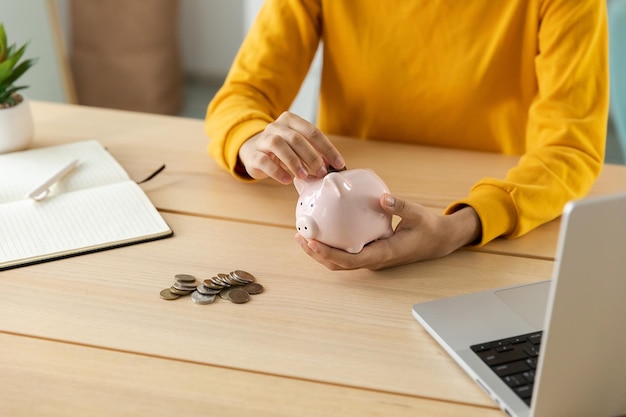 Saving money investment for future Female woman hands holding pink piggy bank and putting money coin Saving investment budget business wealth retirement financial money banking concept