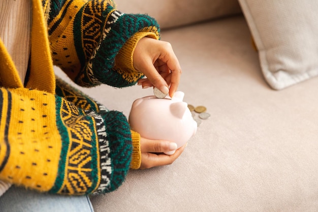 Saving money investment for future female woman hands holding pink piggy bank and putting money coin