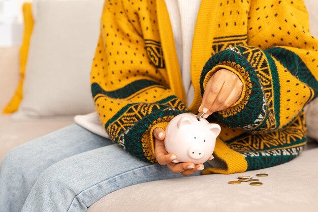 Saving money investment for future female woman hands holding pink piggy bank and putting money coin