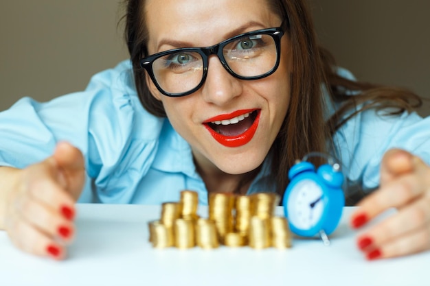 Photo saving smiling woman stacking gold coins into columns