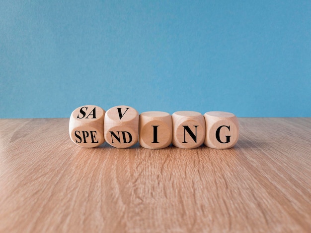 Saving or spending symbol Turned cubes and changes the word 039spending039 to 039saving039