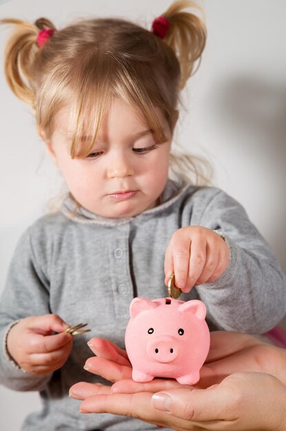 Photo savings concept child holding coin with piggy bank