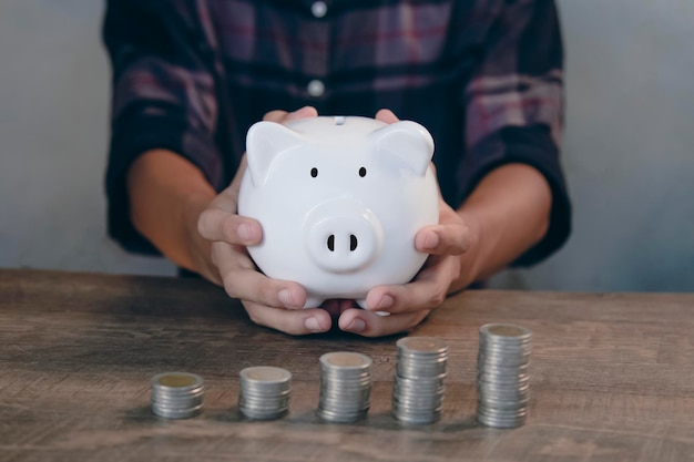 저축 및 금융 투자 돈을 저축하기 위해 돼지 저금통에 동전을 넣으십시오.