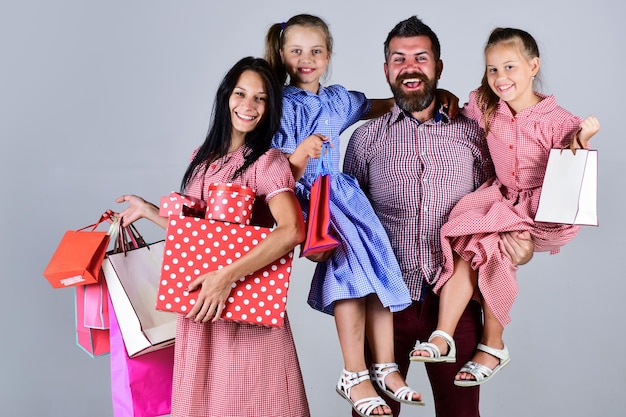 Il risparmio sugli acquisti ha buone vacanze madre padre e figli si preparano per la celebrazione la grande vendita inizia il concetto di venerdì nero famiglia tenere pacchetti e regali famiglia felice andare a fare shopping