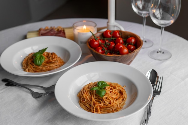 Photo savory bolognese pasta with basil prosciutto cheese and nuts a table set with herry tomatoes