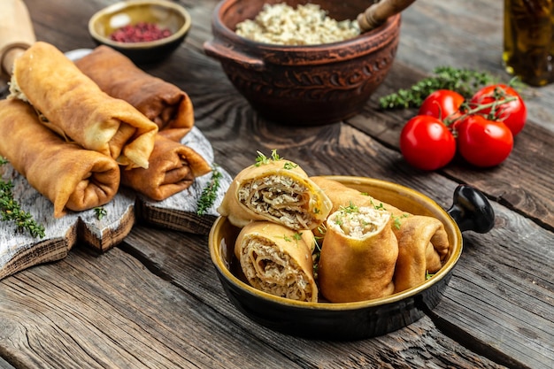 Savory crepe rolls stuffed pancakes with ground meat filling Traditional Russian Maslenitsa festival meal on wooden background