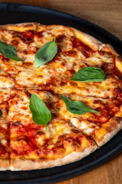 Foto pizza gourmet gustosa su piatto nero