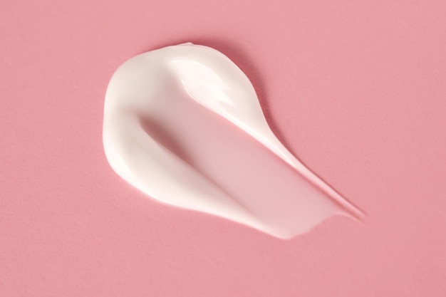 A savory smear of white cream on a pink background