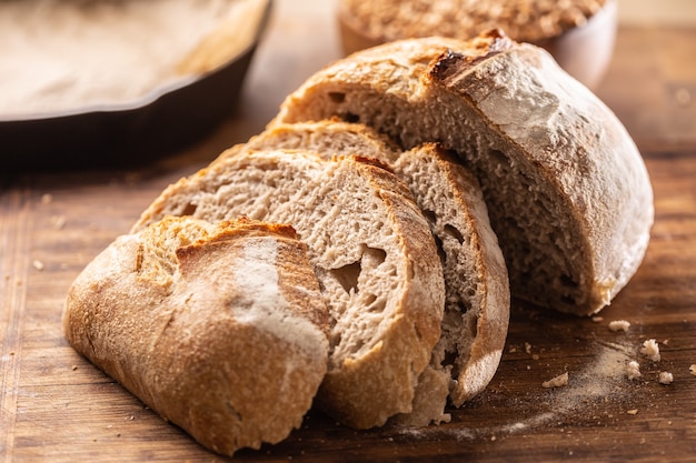 Savoury and crunchy slices of yeast bread with whole wheat grains in the background.