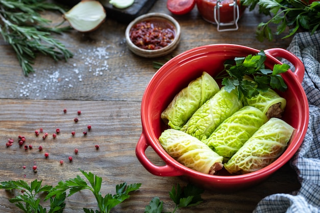 Savoy cabbage rolls stuffed with meat, rice and vegetables on a rustic table.
