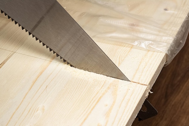 Sawing a wood board with a saw