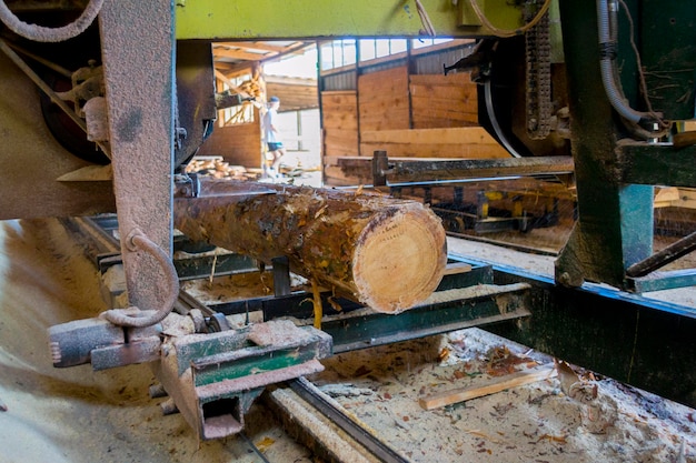 写真 製材所。機器製材所で丸太を機械加工するプロセス機械のこぎりは、板板上の木の幹を鋸で挽きます。木おがくず作業製材材木木工