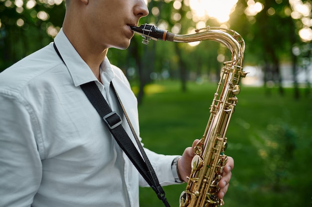 Saxofonist speelt melodie in zomerpark