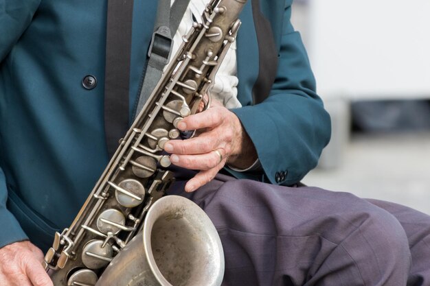 Foto sassofono nelle mani di un musicista di strada