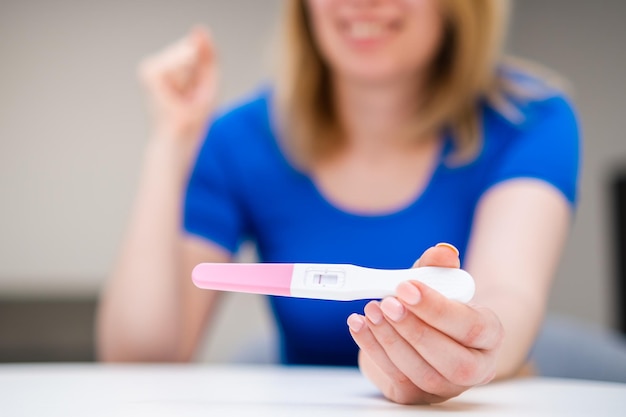 네거티브 임신 테스트를 받는 행복한 젊은 여성이 아기를 가질 준비가 되지 않았다고 말하세요