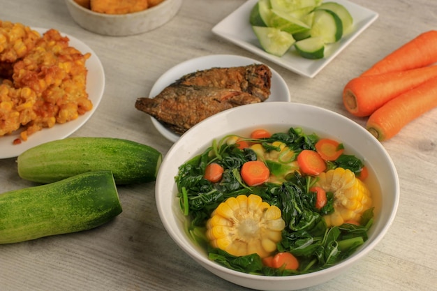 Sayur Bening Bayam은 시금치, 당근, 옥수수로 만든 인도네시아 가정의 일일 메뉴입니다. 마늘과 소금으로 양념. 두부나 소금에 절인 생선 튀김, 삼발과 같은 다양한 반찬과 함께 제공됩니다.