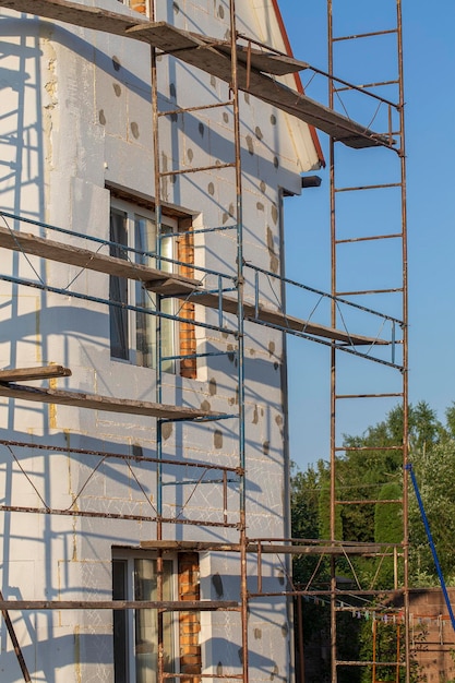 Scaffold on house renovation House for renovation with the scaffolding for workers on building