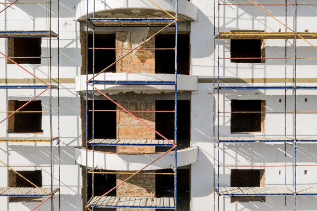 Scaffold near the high-rise building for plaster