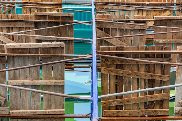 Scaffolding with wooden decks, bottom view. performing\
construction work at height. construction safety.