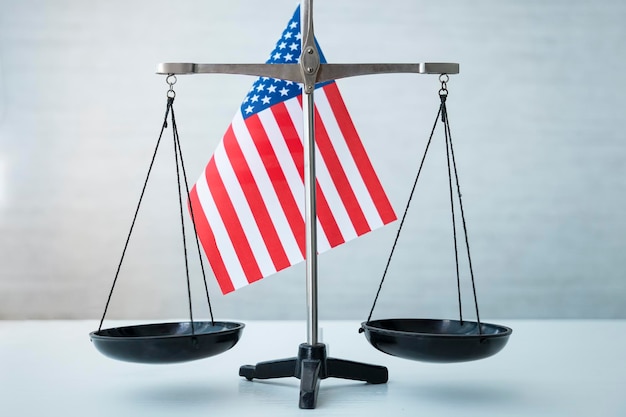 Scales of justice with american flag on wooden table