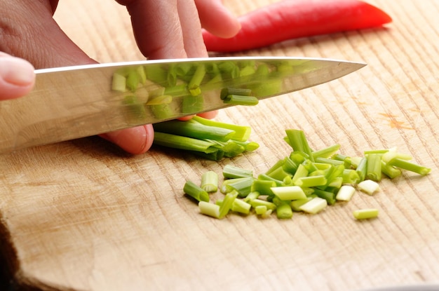 Scallions being cut on cutting board