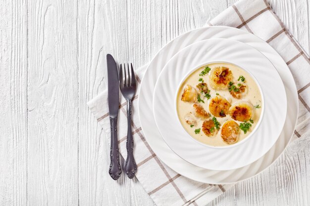 Photo scallops with white wine cream sauce in bowl