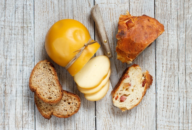 Scamorza, formaggio affumicato italiano tipico e pane fatto in casa sulla tavola di legno