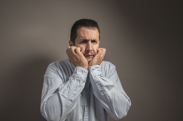 Photo scandalized man with hands on his face