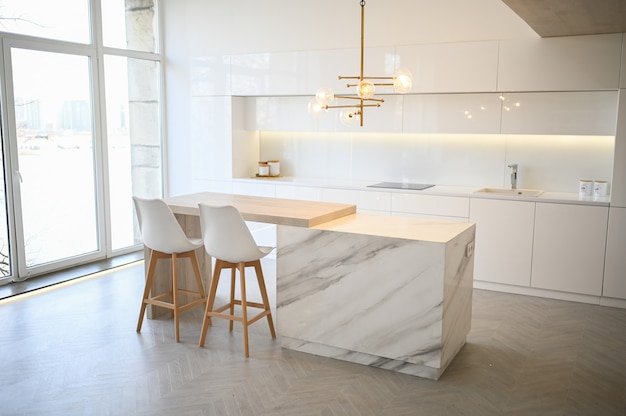 Scandinavian empty classic modern luxury kitchen with wooden, white, marble details, new stylish furniture, minimalistic nordic interior design. Bar stools