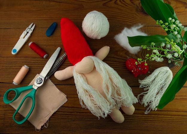 Scandinavian gnome making step by step handmade tutorial wooden background Homemade fabric swedish Christmas decoration DIY Hobby soft stitched stuffed toy long beard red hat sewing hygge concept