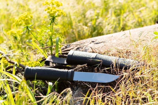 Scandinavian knife with plastic sheath Swedish fixed blade knife Knife in the flower field Knife on the grass Front view