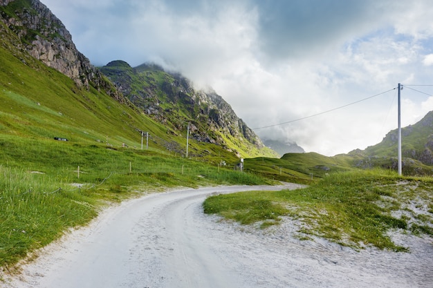  scandinavian landscape with meadows, mountains and road. Car trip on Lofoten islands, Norway.