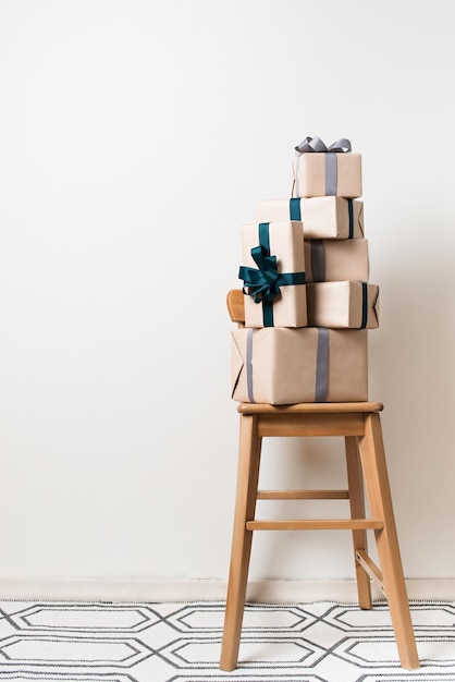 스칸디나비아 미니멀리즘 크리스마스와 새해 컨셉의 선물 상자는 흰색 배경 복사 공간에 있는 의자에 있습니다.