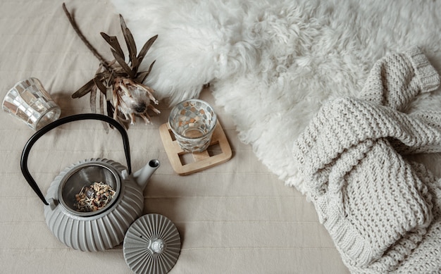 Scandinavian style teapot with knitted tea and decor details top view.