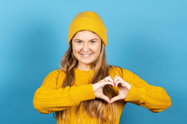 Scandinavian teenager girl making heart shape with hands