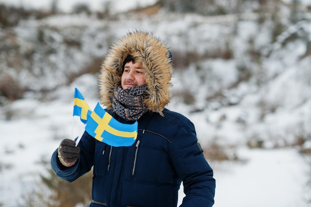 Scandinavische man met Zweedse vlag in zweeds winterlandschap