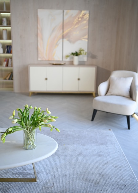 Scandinavische stijl lichte klassieke moderne luxe witte woonkamer met marmeren tafel, nieuwe stijlvolle meubels, ladekast, gezellige fauteuils, kamerplanten. Minimalistisch Scandinavisch interieurontwerp