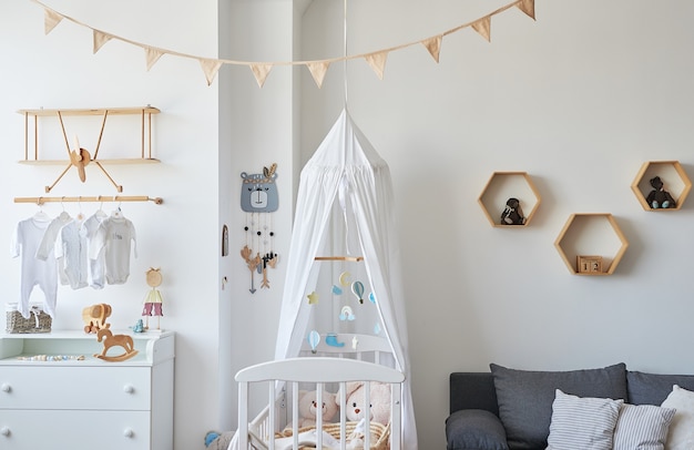 Scandinavische stijl wit interieur kinderkamer, slaapkamer, kinderkamer. Babybedje met â€luifel. Houten planken en speelgoed. Houten plank in de vorm van een vliegtuig