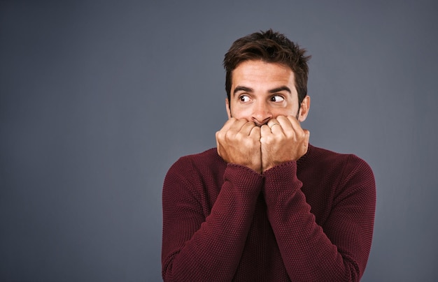 Scared afraid and phobia of man in studio anxiety and biting of nails for stress worry and fear Gray background mockup space and person with terror for nightmare of fail in test of college