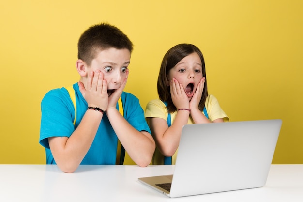 Scared boy and girl watching laptop