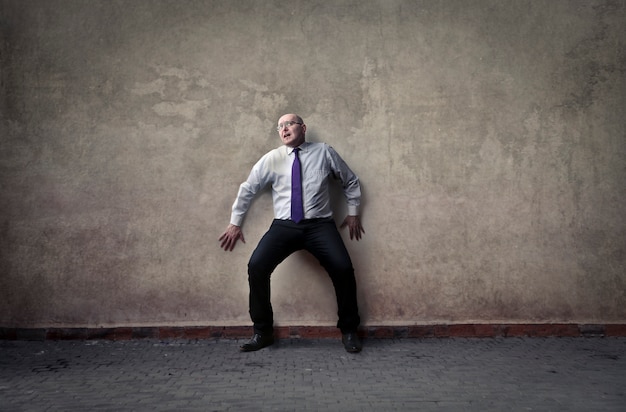 Scared businessman on the wall