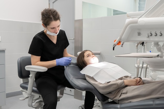 Photo a scared child in a dental chair at a pediatric dentists appointment