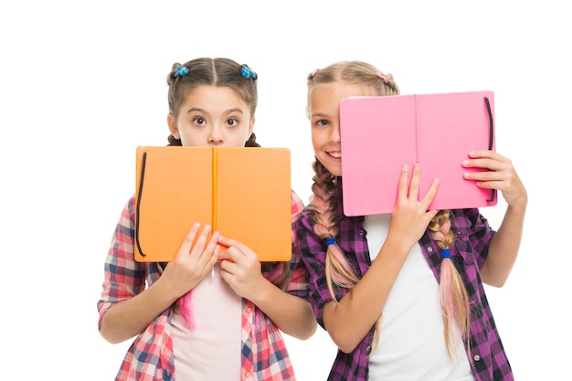 Scared of exams. back to school. literature lesson. study homework. schoolgirls with notebook isolated on white. do homework together. learning language together. surprised pupils with work book.