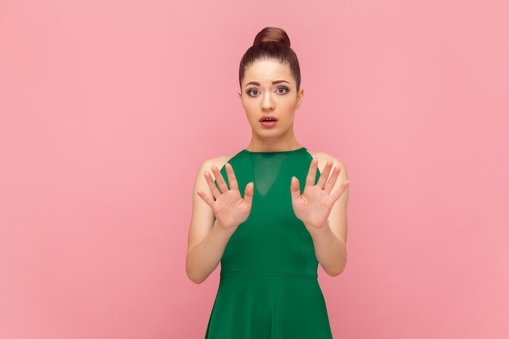 Photo scared frighten woman standing showing palms to camera demonstrates stop sign asking to stop it