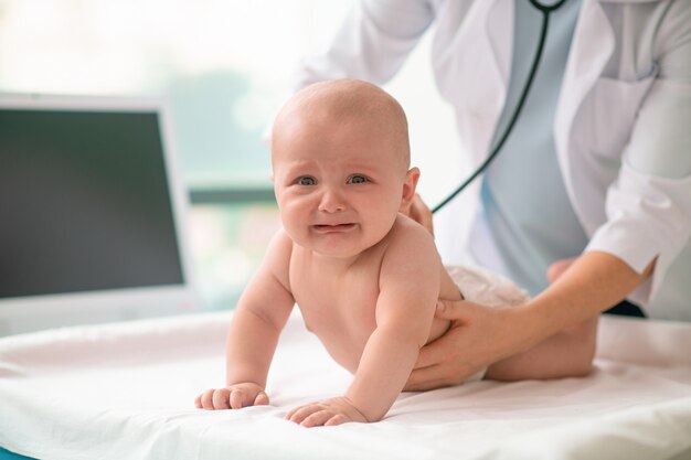 Bambino spaventato che guarda la telecamera durante l'esame medico