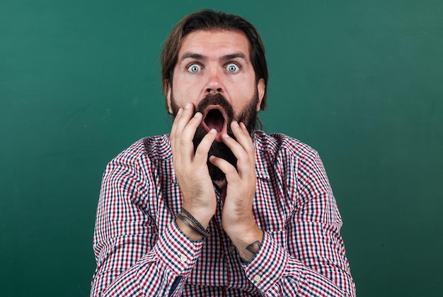 Scared male hipster having surprised face with beard and moustache, horror.